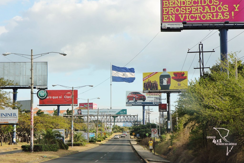 A bandeira nicaraguense sobressai em meio às inúmeras propagandas na entrada de Manágua